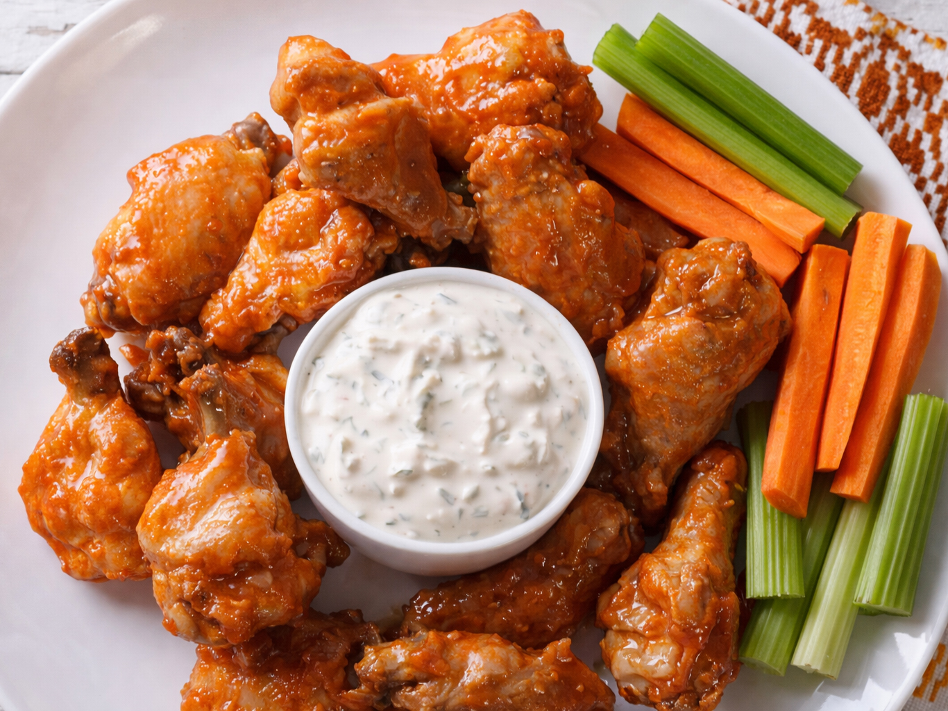 Plate of buffalo chicken wings with bleu cheese dip, celery, and carrot sticks