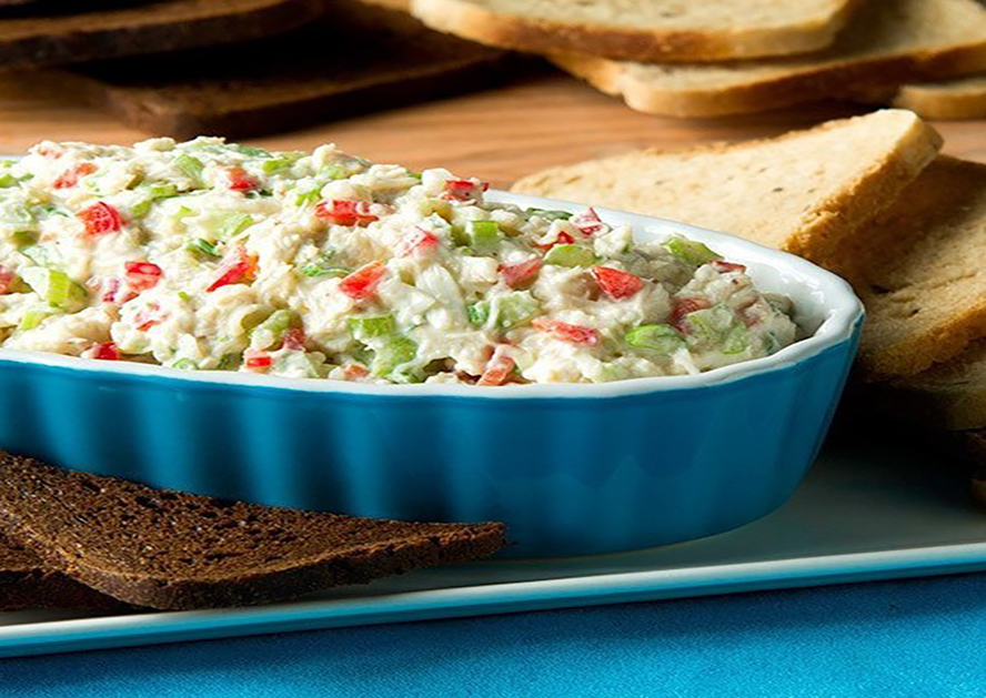 Blue dish of crab dip with toast and crackers