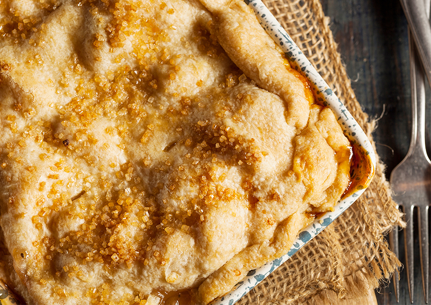 Baked cobbler in a square dish with a golden, sugar-topped crust