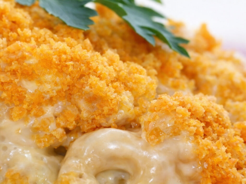 Close-up of baked macaroni and cheese with a golden breadcrumb topping and parsley garnish