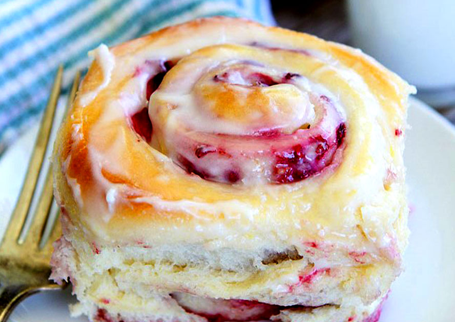 Iced raspberry cream roll on a plate with a fork