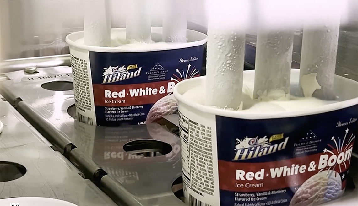 Hiland Red, White & Boom Ice Cream containers on a production line being filled from vertical nozzles dispensing ice cream
