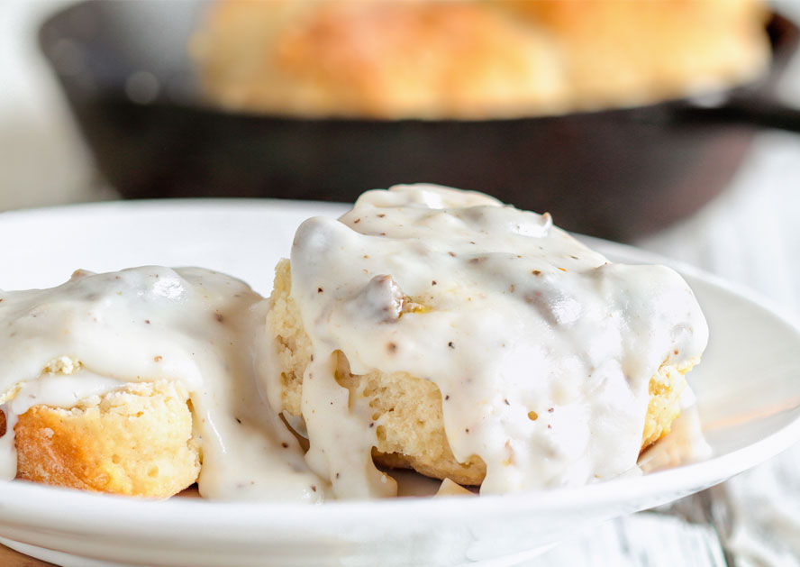 Biscuits topped with white sausage gravy on a plate