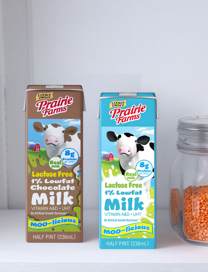 Prairie Farms Lactose Free Moo-licious chocolate and white milk cartons displayed on a pantry shelf beside a glass storage jar filled with dry lentils.