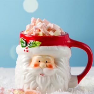 Santa-shaped mug filled with a festive drink and topped with mini marshmallows.