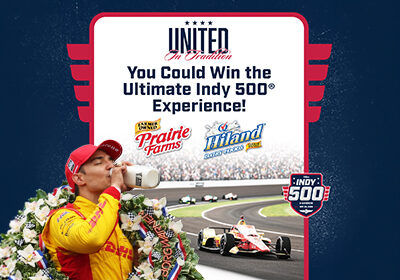 Promotional graphic featuring a race car driver drinking milk in victory lane, with text reading “United In Tradition” and “You Could Win the Ultimate Indy 500 Experience!” alongside Prairie Farms, Hiland Dairy Foods, and Indy 500 logos