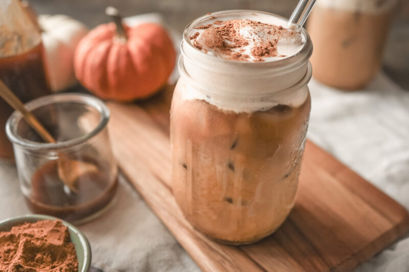 Iced pumpkin spice latte topped with creamy pumpkin spice cold foam and a dusting of pumpkin pie spice, served in a mason jar.